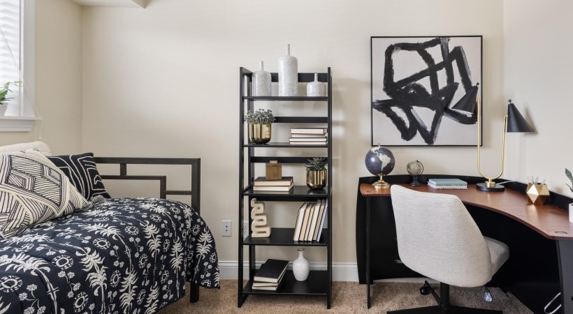 a bedroom with a bed desk and a shelf with books